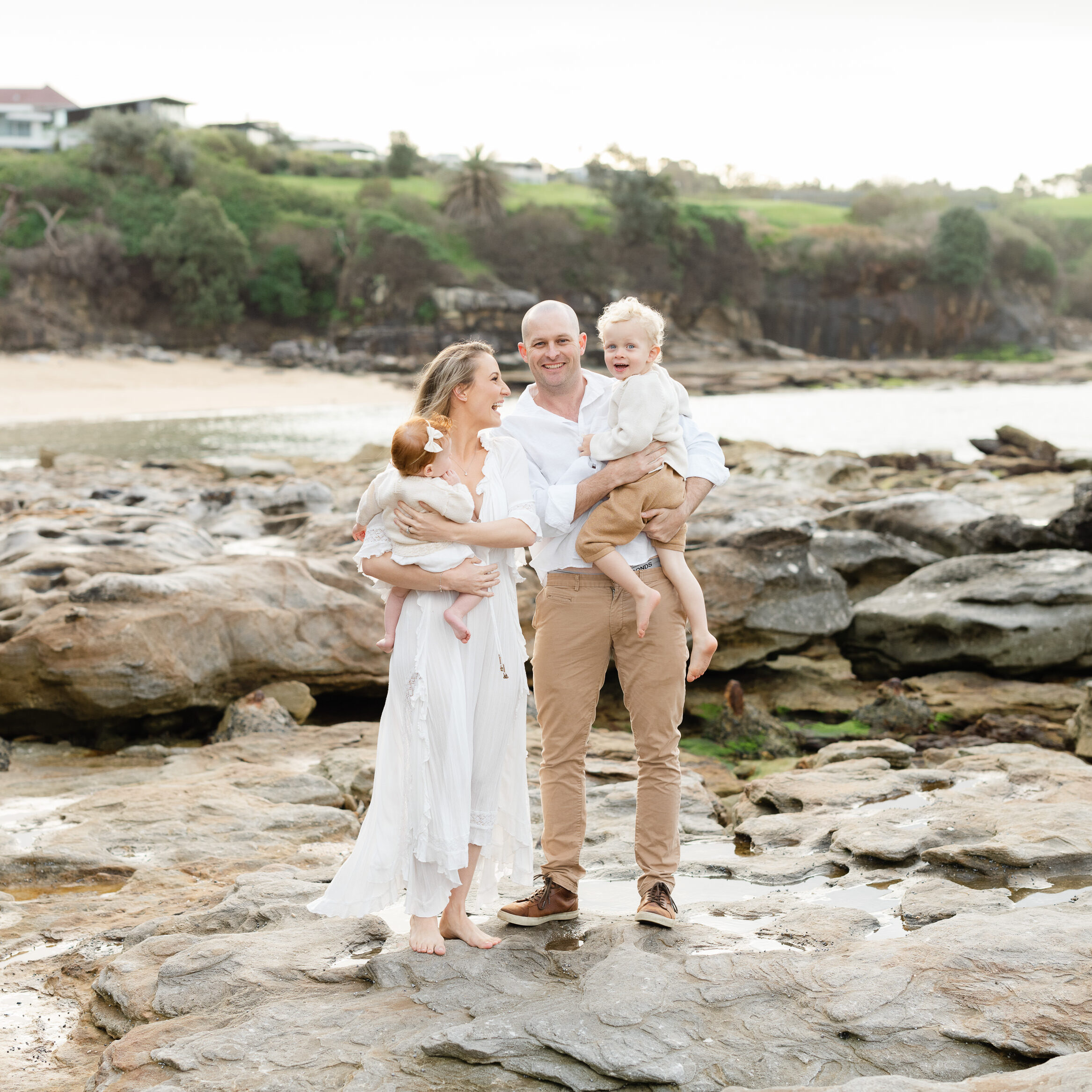 Family standing on rocky beach for a family photo session in Sydney