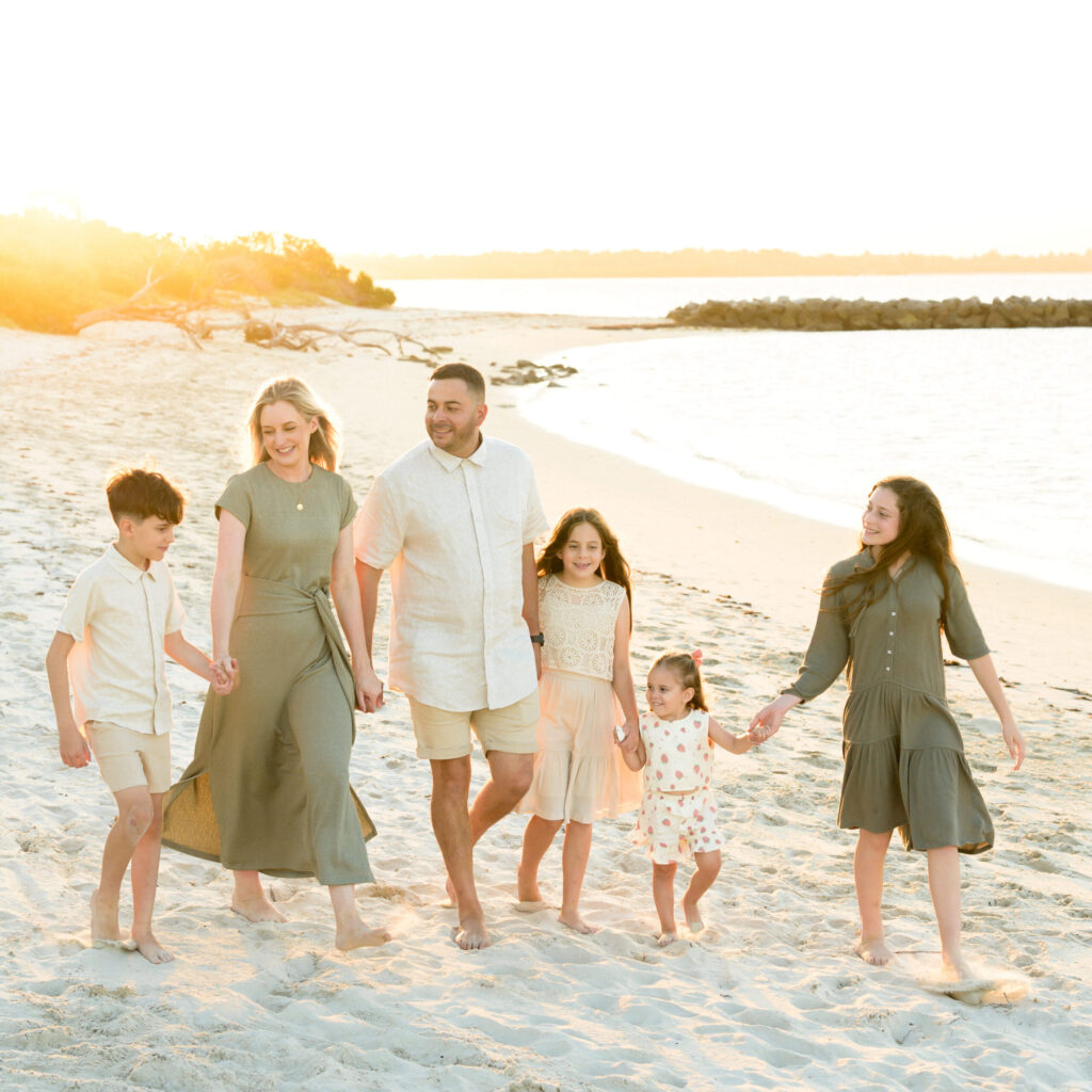 Family dressed in co-odinating outfits for family photos on the beach in Sydney