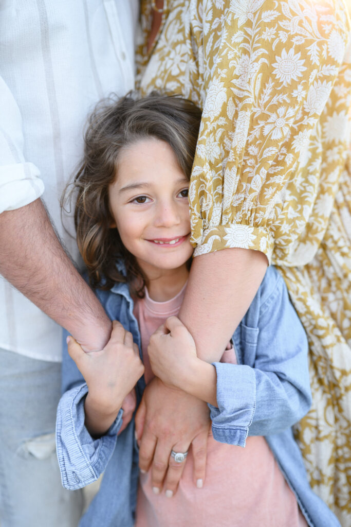 Sutherland Shire family photoshoot - close up of young boy with parents arms around him