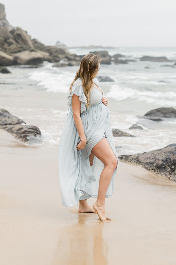 Pregnant mother standing on the sand at a beach in the Sutherland Shire Sydney